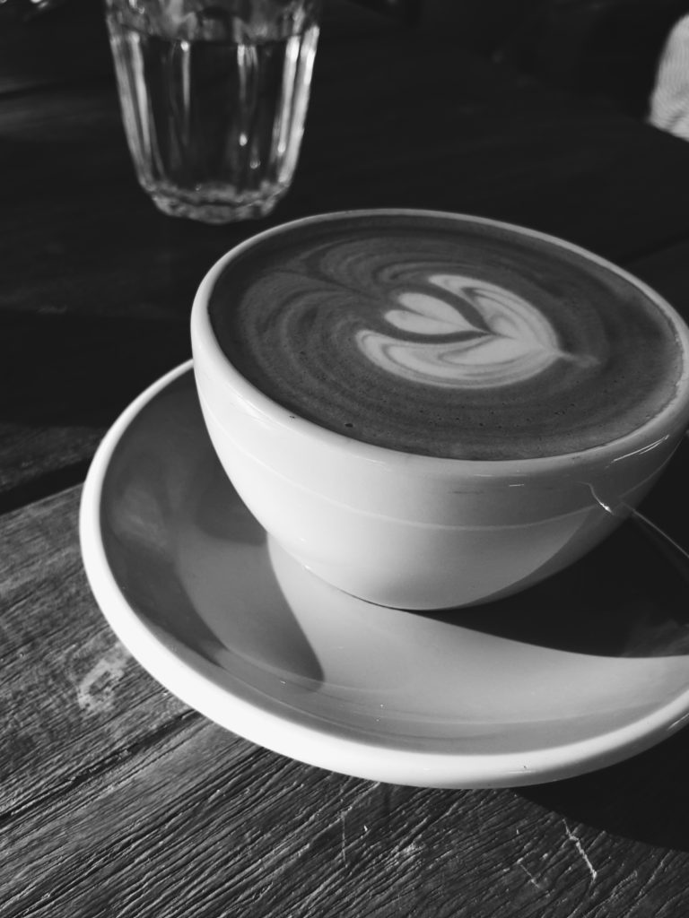 Black and white photo of a flat white coffee at a cafe